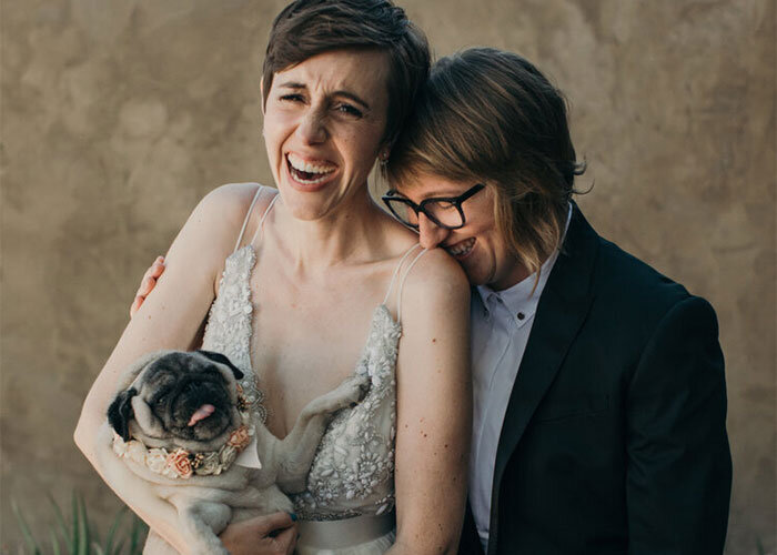 Newlyweds laugh while holding pet pug after wedding ceremony Richmond Virginia Betty Clicker Photography