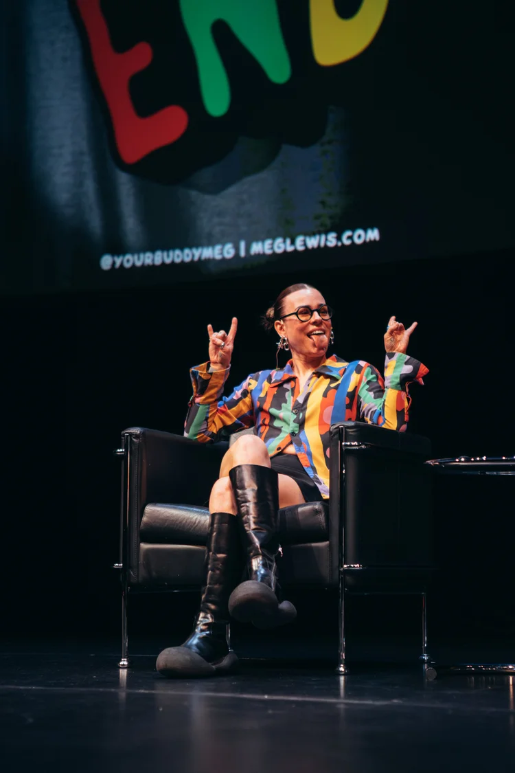 Meg laughing on stage with rock-on hands