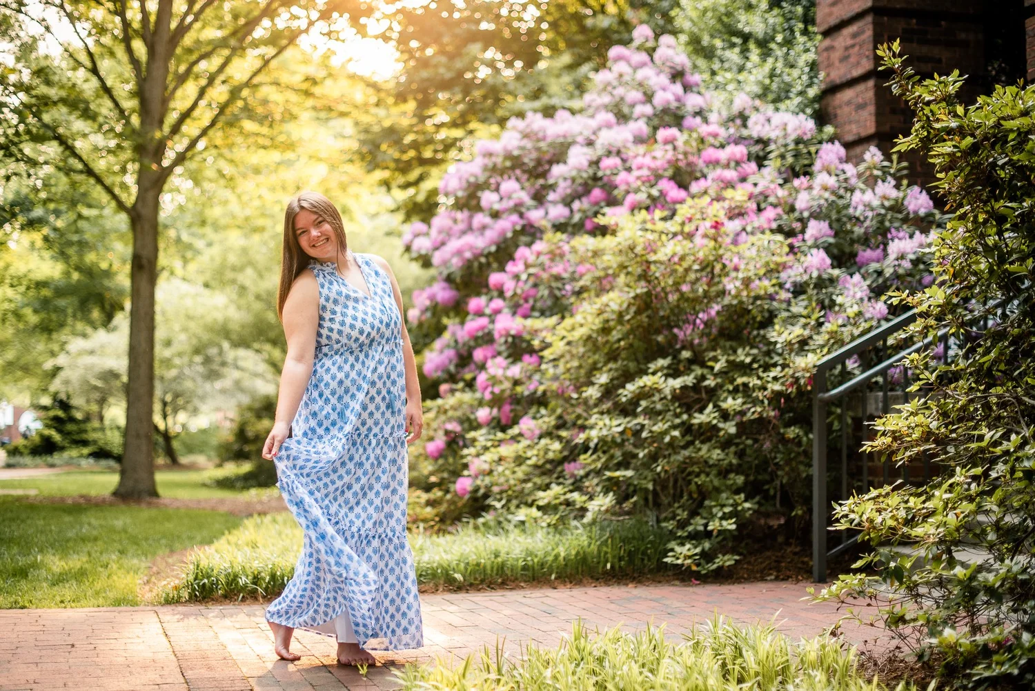 Elon student among blooming spring shrubs on campus
