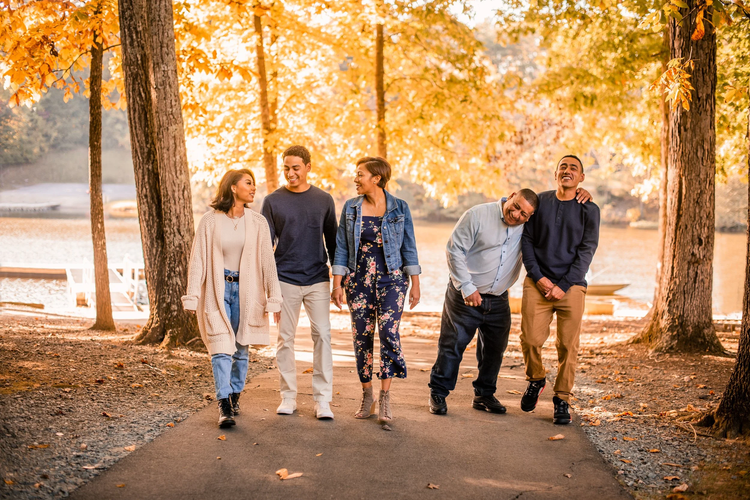 Family walking together under golden fall foliage in Burlington, NC