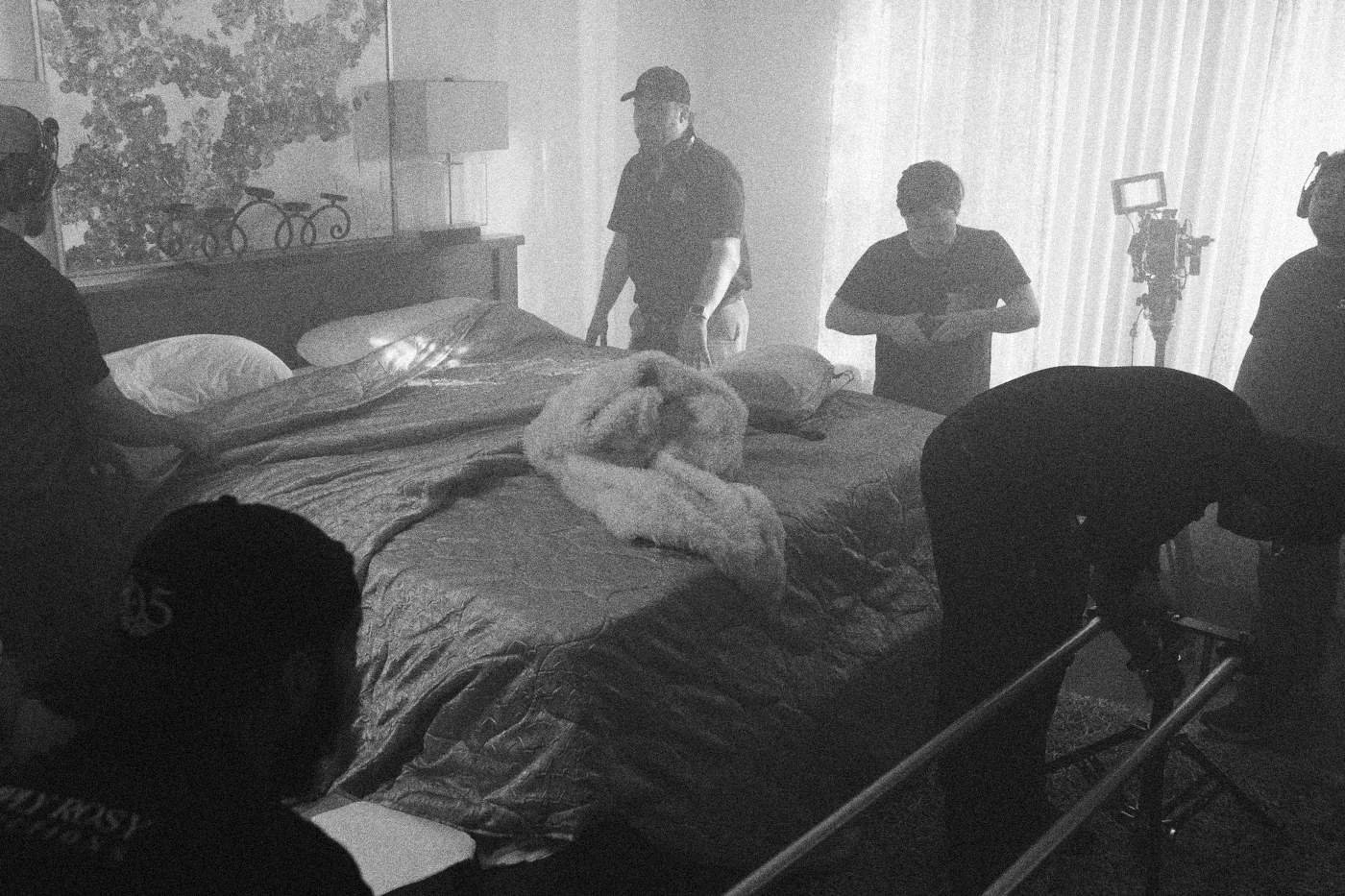 Behind the scenes on INERTIA: crew members set up around a bed in a teal lit bedroom.
