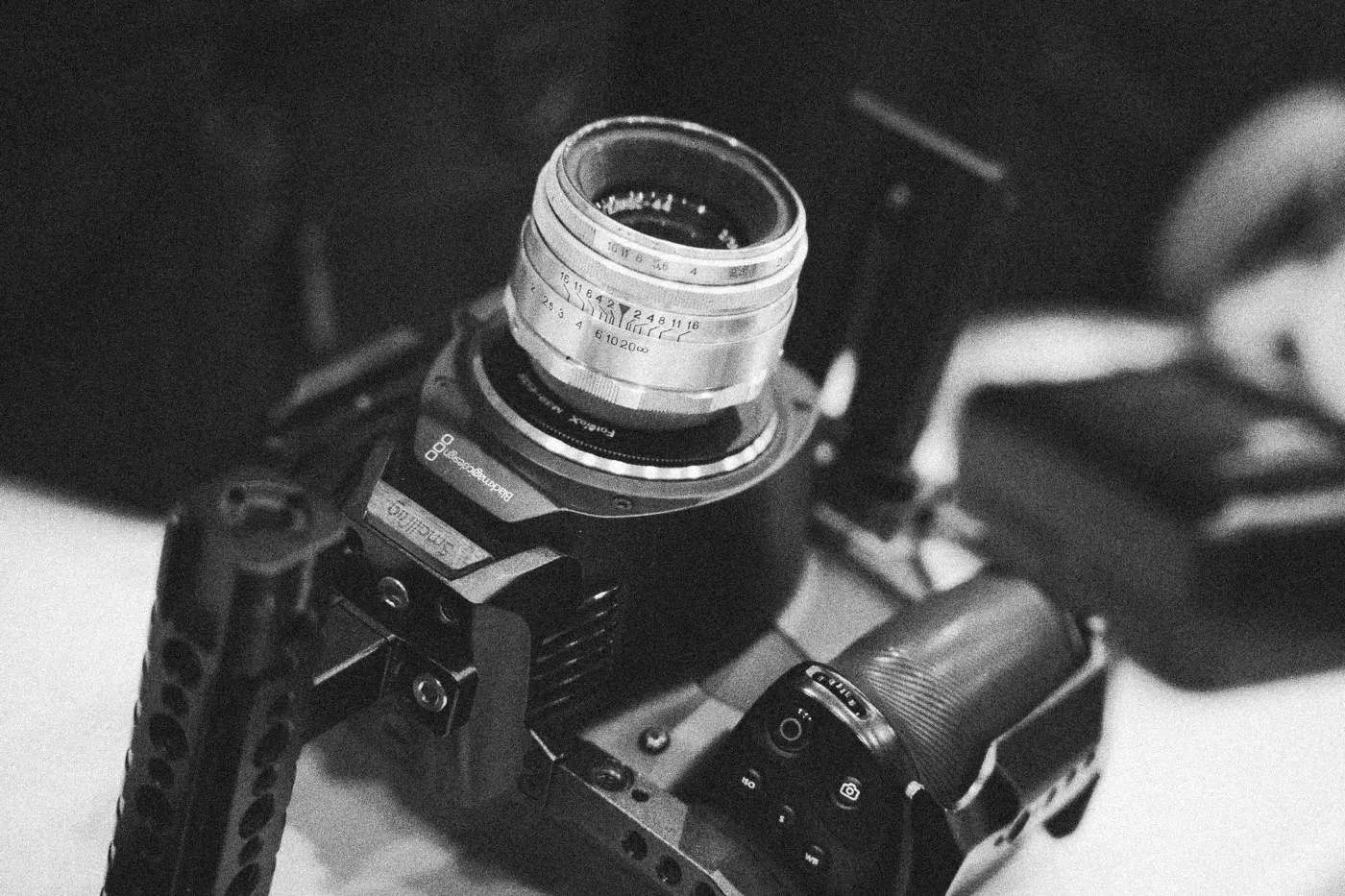 Behind the scenes on INERTIA: close detail of a cinema camera body fitted with a vintage lens.