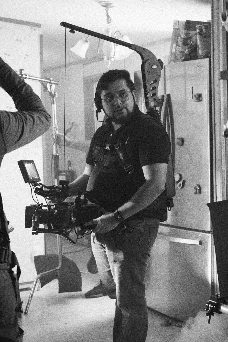 Behind the scenes on INERTIA: a camera operator with a rigged camera standing in a kitchen.