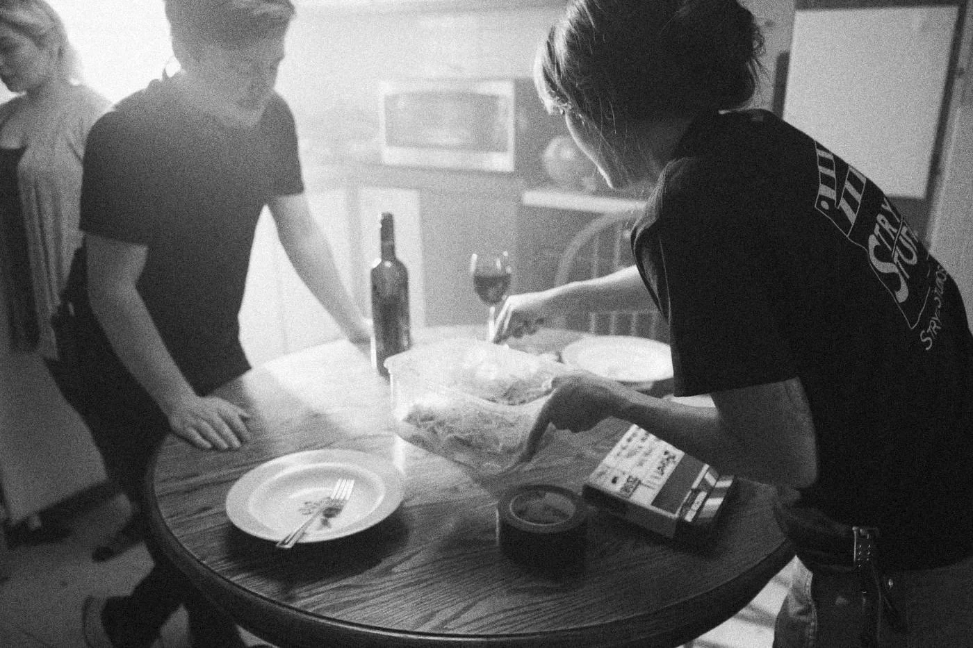 Behind the scenes on INERTIA: crew members dress a kitchen table with plates, a wine bottle and snacks.