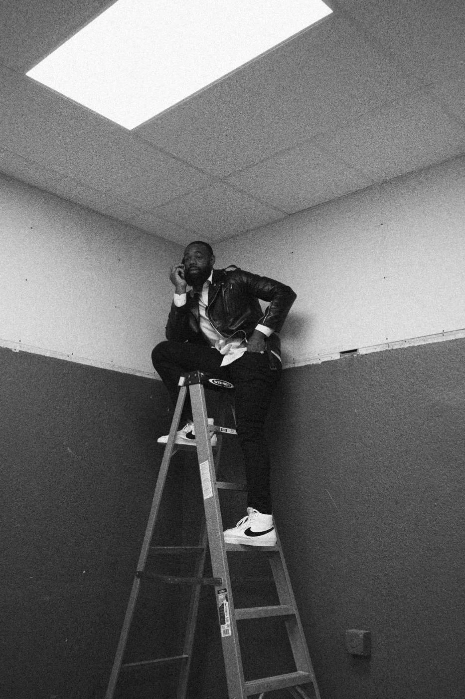 Behind the scenes on INERTIA: a person on a stepladder in the corner of a purple room.