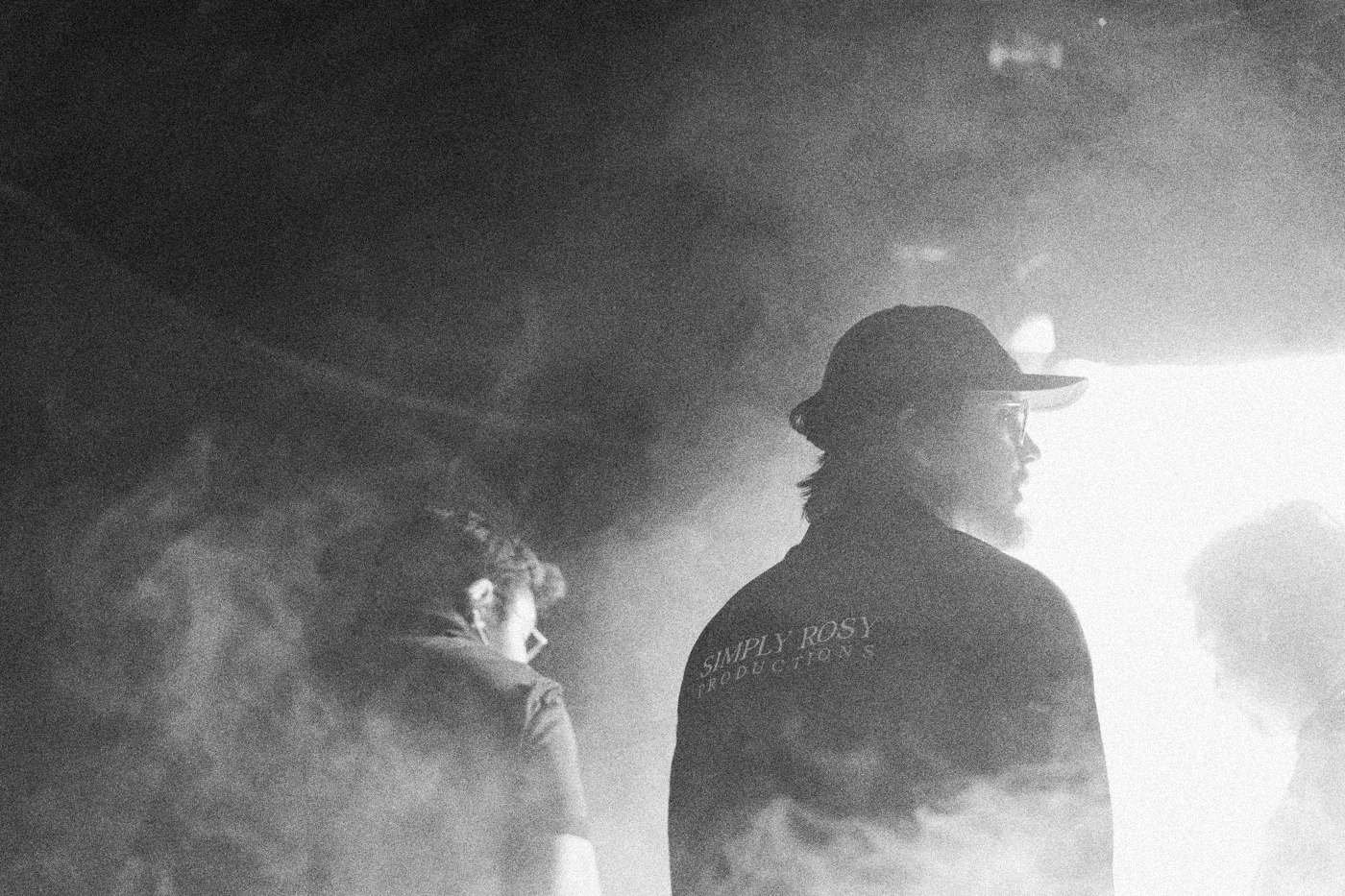 Behind the scenes on INERTIA: crew members stand in thick haze lit from behind, partly in silhouette.