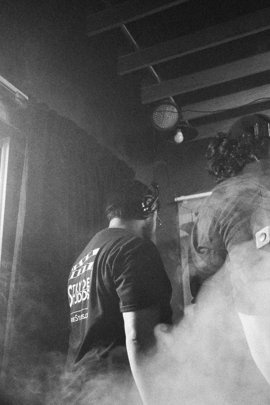 Behind the scenes on INERTIA: crew members seen from behind in haze.