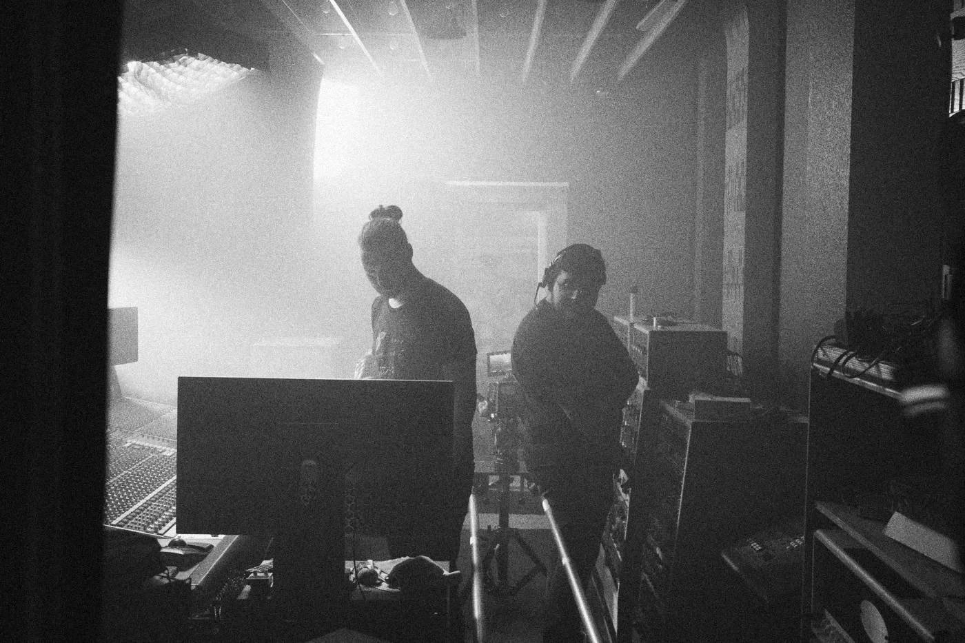 Behind the scenes on INERTIA: crew members work in a hazy studio lit from behind.