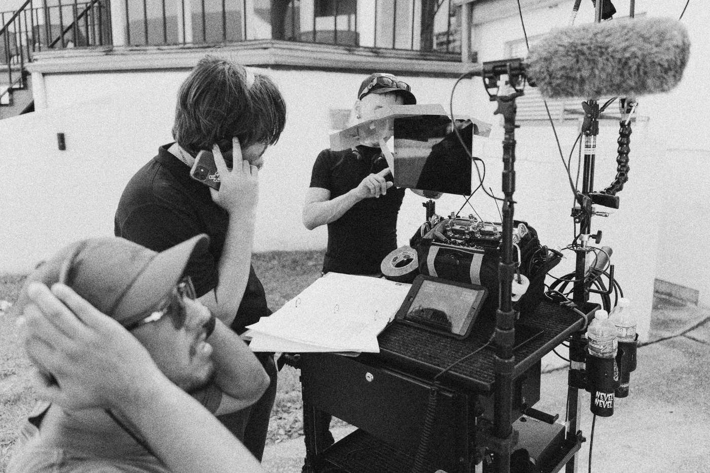 Behind the scenes on INERTIA: the sound team works at a cart with a recorder, a tablet and an open script binder in daylight.