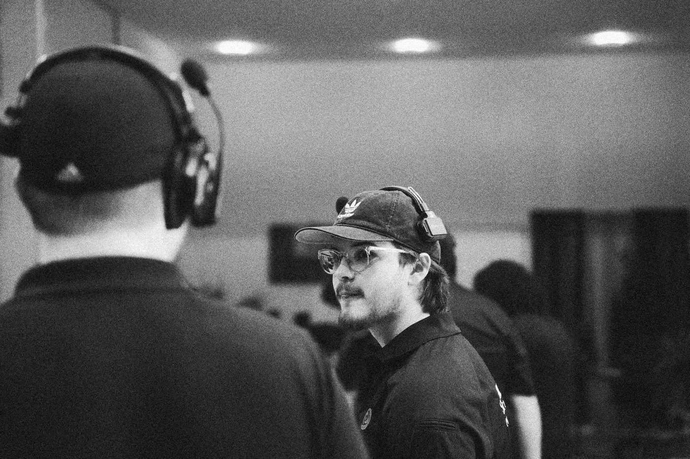Behind the scenes on INERTIA: two crew members in headsets talk on set, one seen from behind in the foreground.