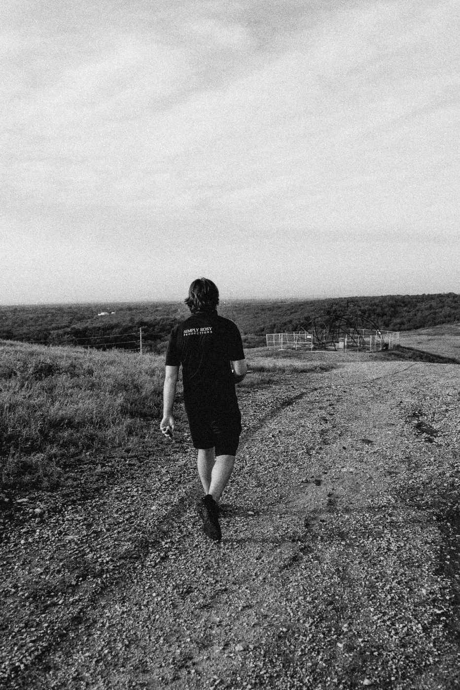 Behind the scenes on INERTIA: a crew member walking away down a dirt road.