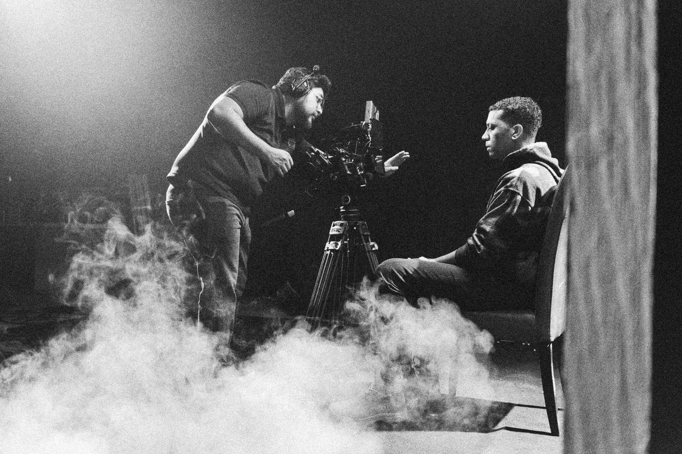 Behind the scenes on INERTIA: a camera operator films a seated actor as haze rolls across the floor.