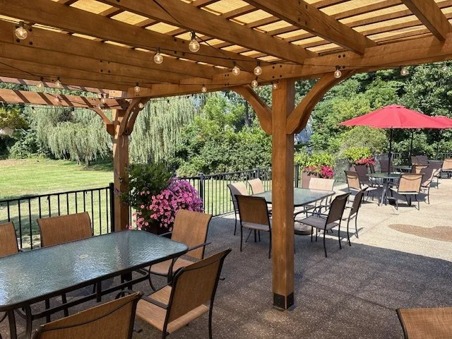 Bocca Grande patio with a wooden pergola, string lights, and garden seating