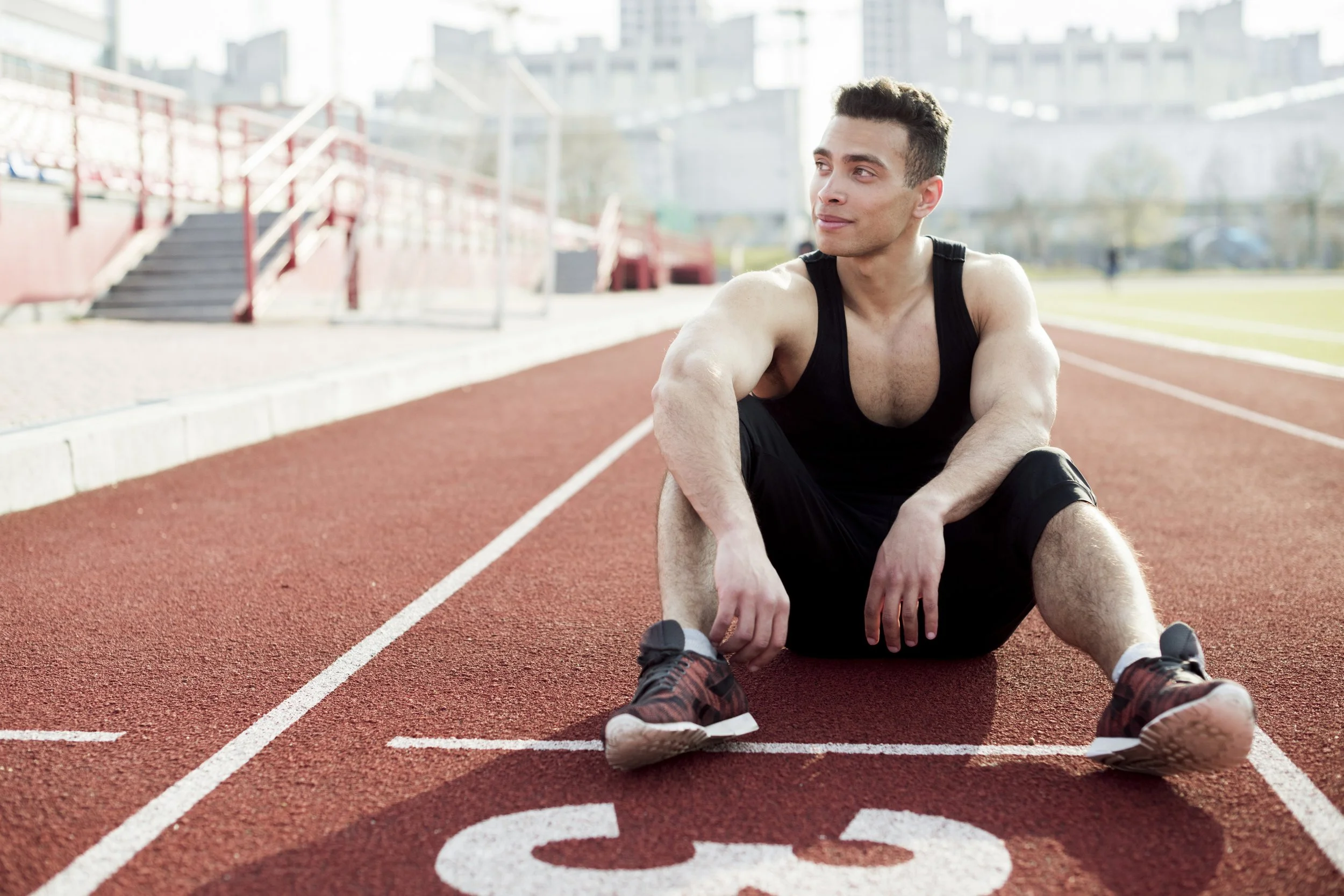 Male athlete resting on athletics track