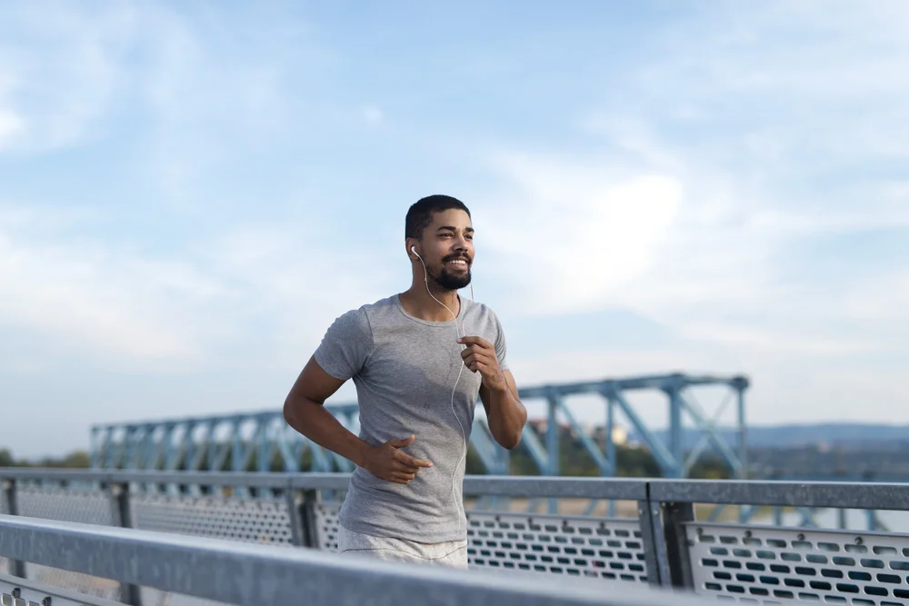 An athlete running across a bridge
