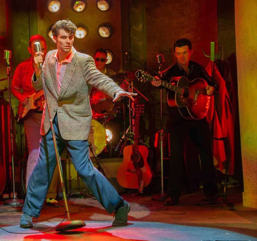A performer at the microphone in Million Dollar Quartet