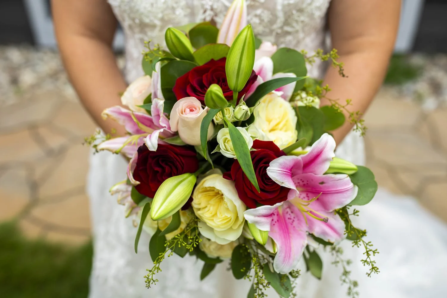Bride holding a bouquet of lilies and roses
