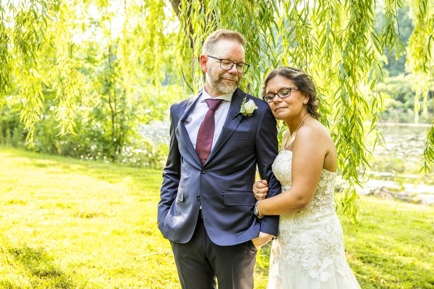 Couple standing together under the willow trees