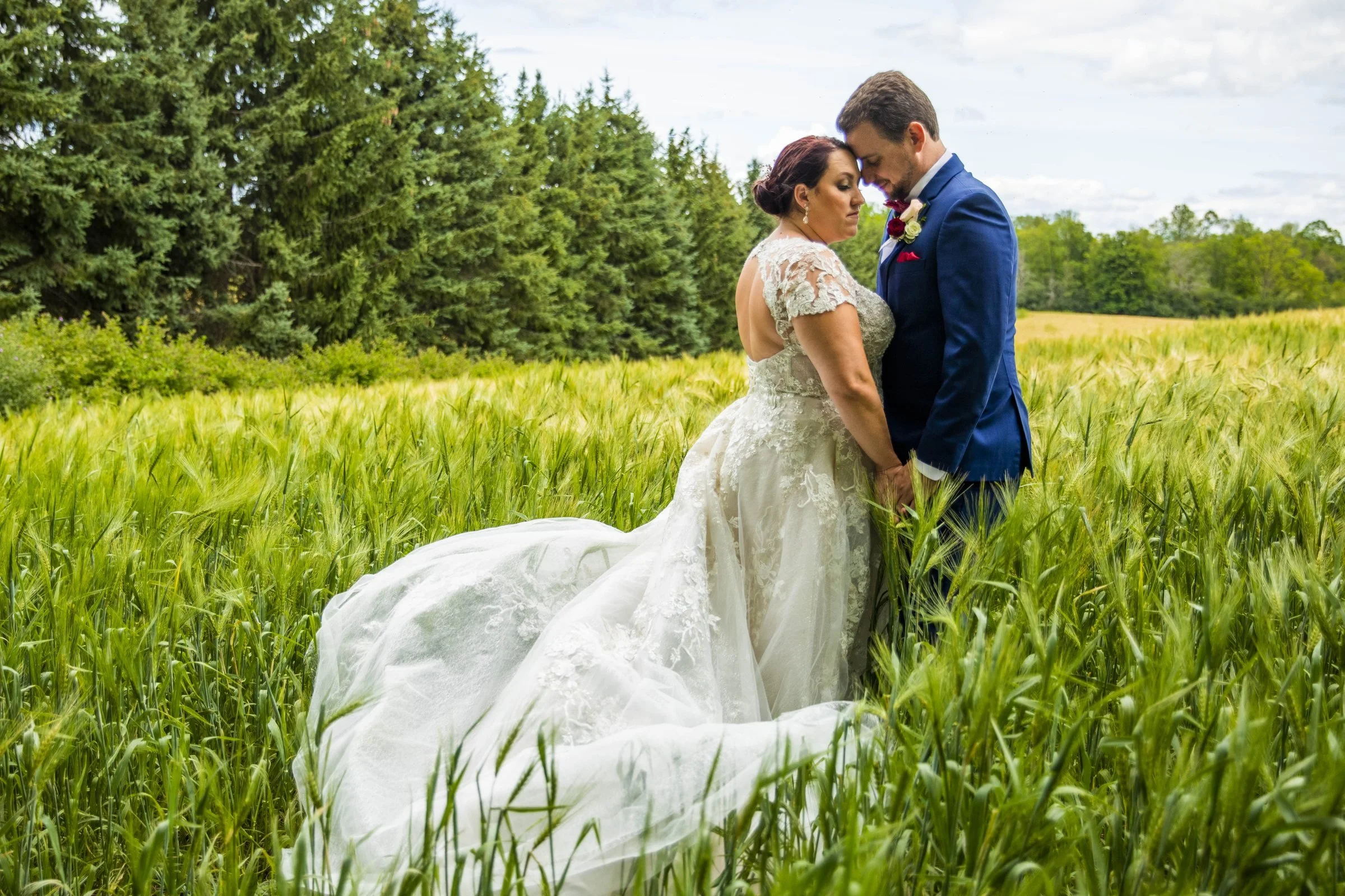 Bride and groom embracing in a wheat field