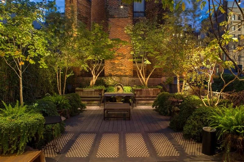 Urban outdoor courtyard illuminated with integrated lighting and audio elements