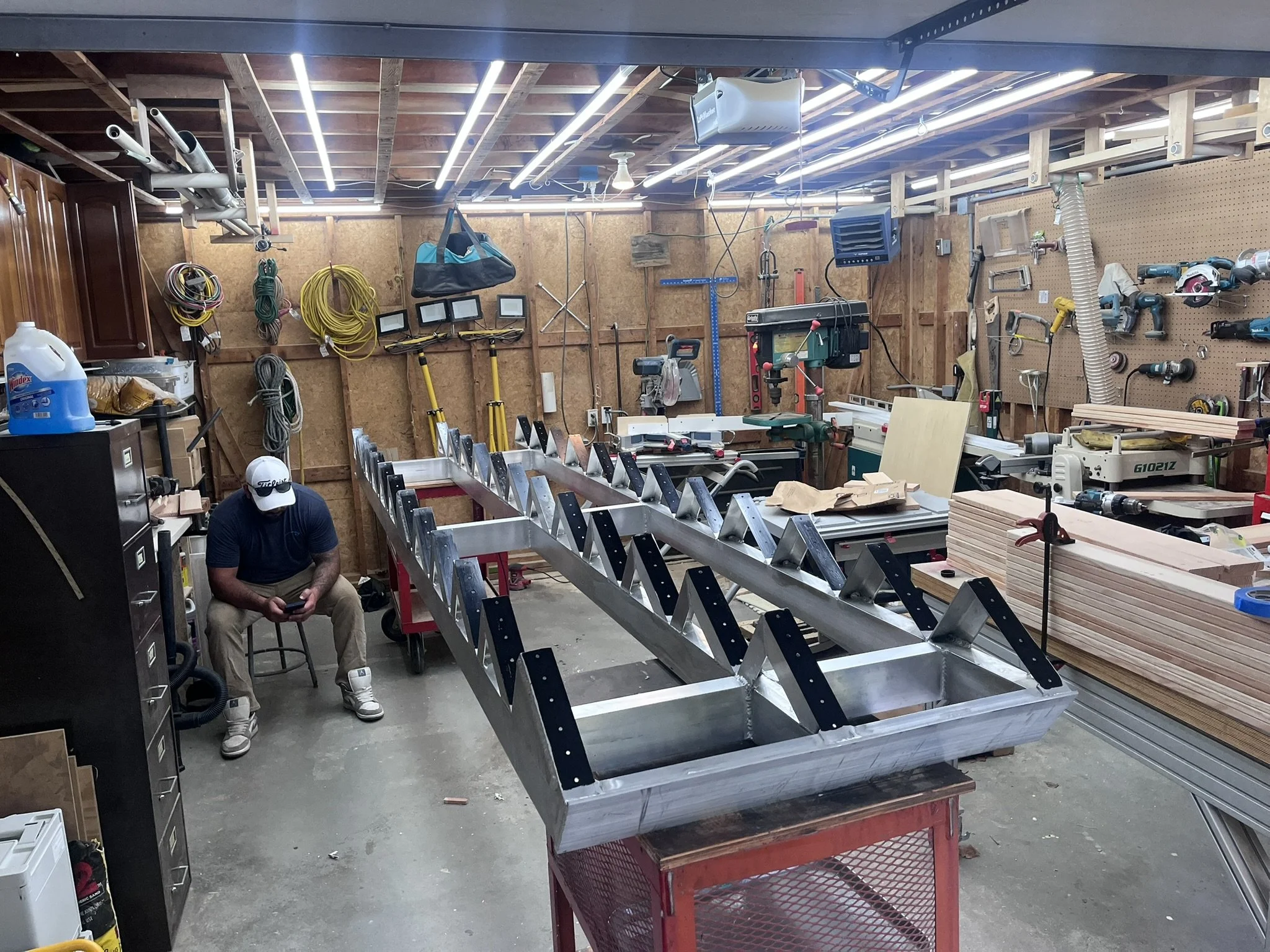 Workshop overview with completed aluminum frame and fabricator