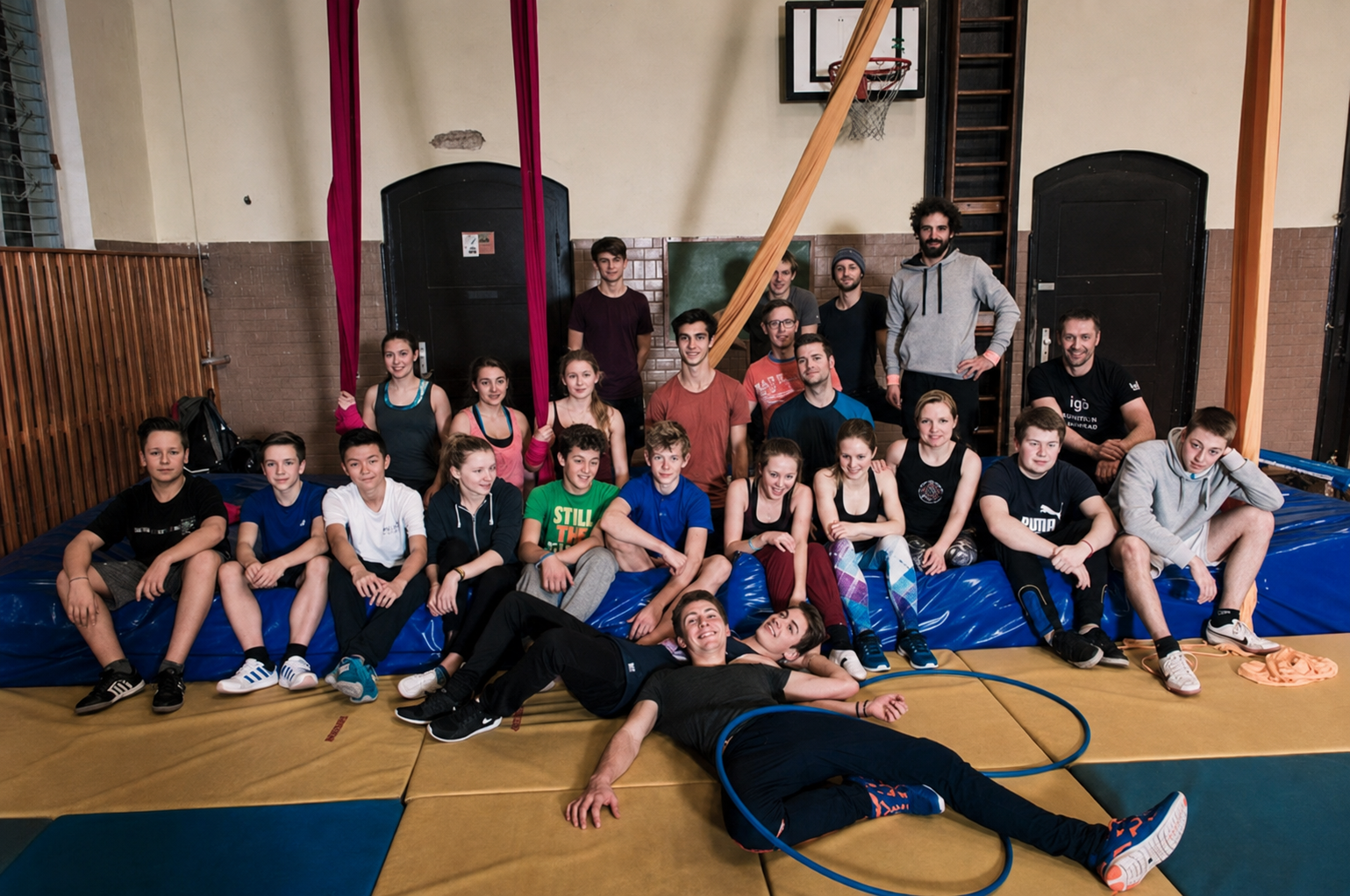 Workshopgruppe beim gemeinsamen Akrobatiktraining in einer Turnhalle
