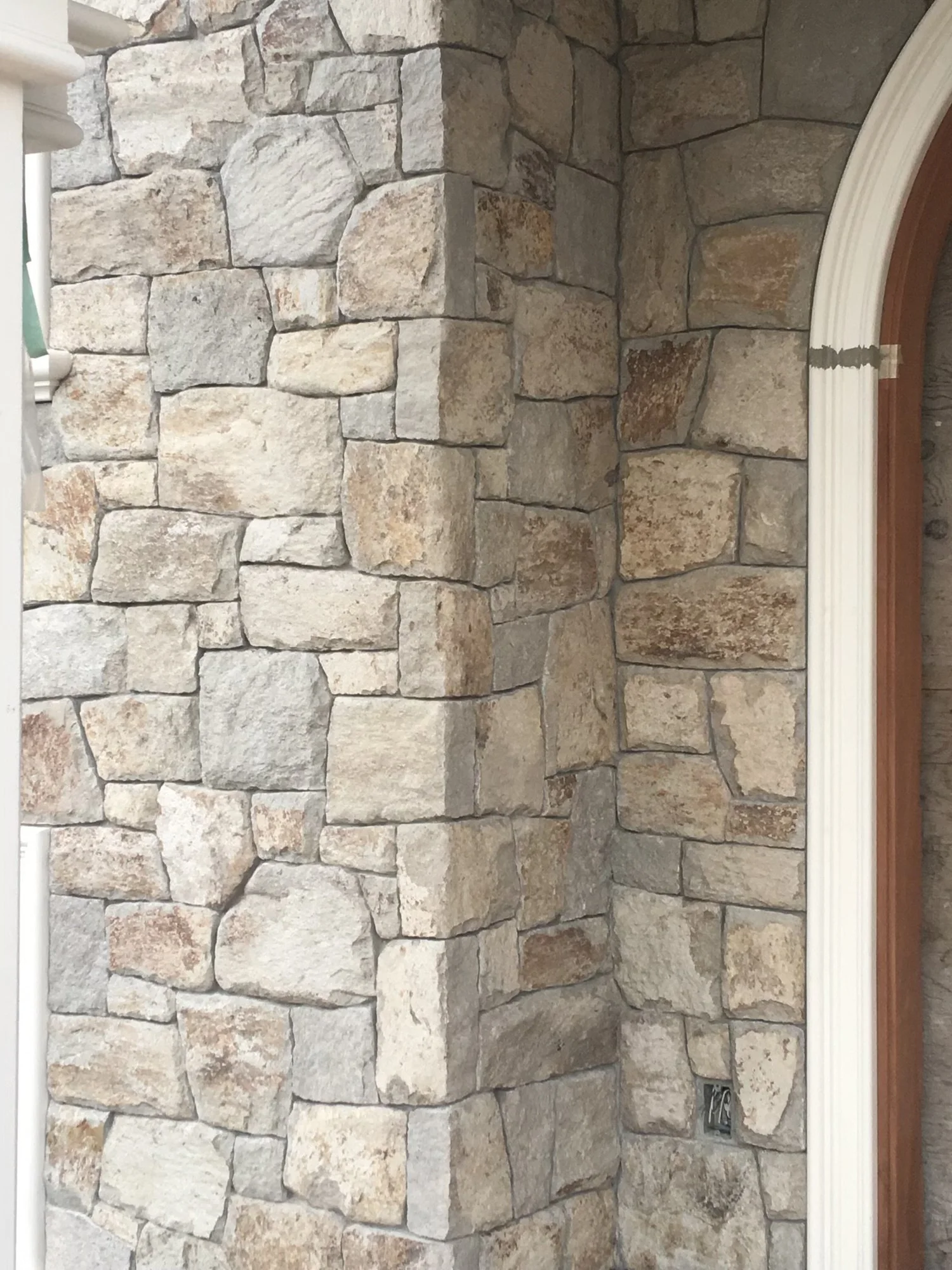Natural-face Rhyolite field veneer framing an entry.