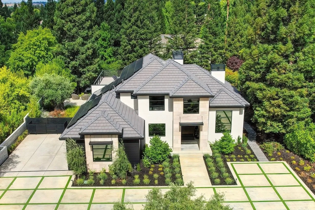 Seen from above, pale Indiana Limestone Buff sits under dark hipped roofs, with clipped hedge rows and a jointed motor court laid out below.
