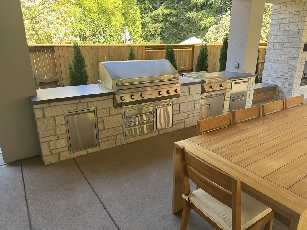 Norway faces the outdoor kitchen run, its pale coursing carrying under a stainless grill and counter.