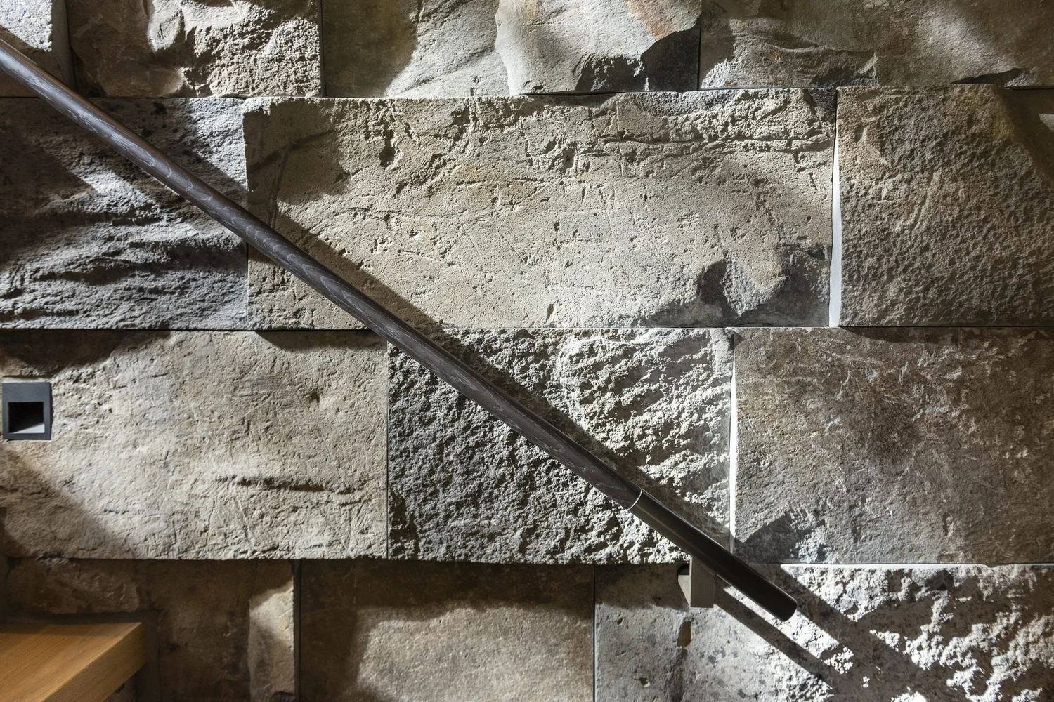 Whistler Basalt panel veneer in a natural face with dry-stack joints on an interior staircase wall.
