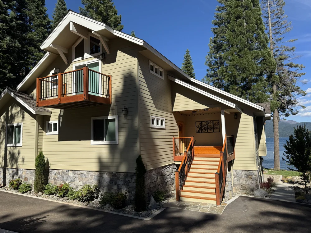 Gallatin River veneer wrapping a lakeside facade above timber stairs.
