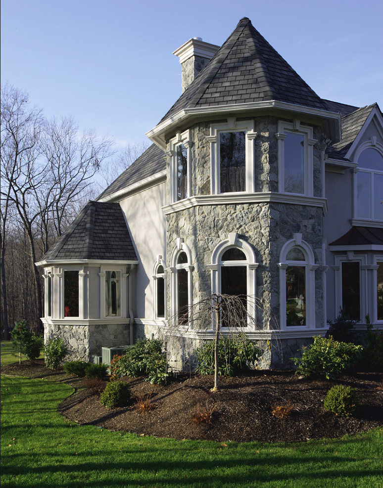 Bluewater wraps a shingled turret and the lower walls of a Victorian elevation, white trim picking out the arched windows.