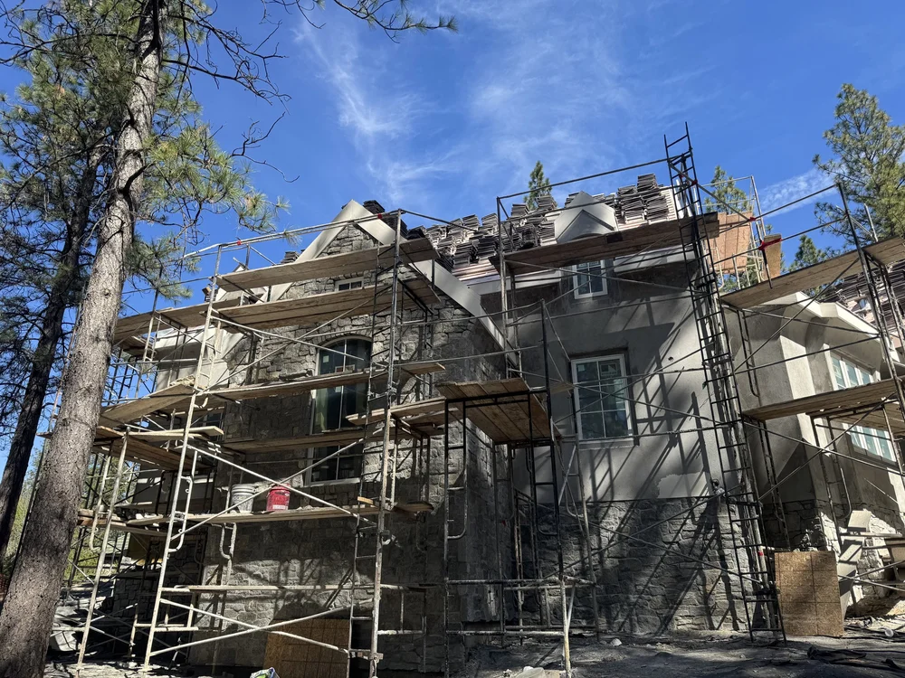 Rocky Mountain Granite goes up behind scaffolding on a house in the pines.