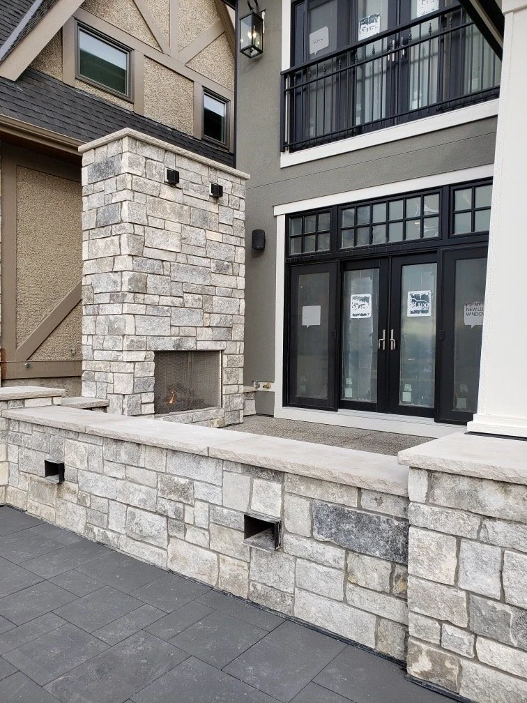 Blue builds an outdoor fireplace and the seat wall running the patio beside it, in cream and gray courses.
