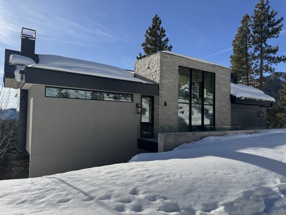 Avalon veneer meets dark metal cladding along a snow-covered roofline.