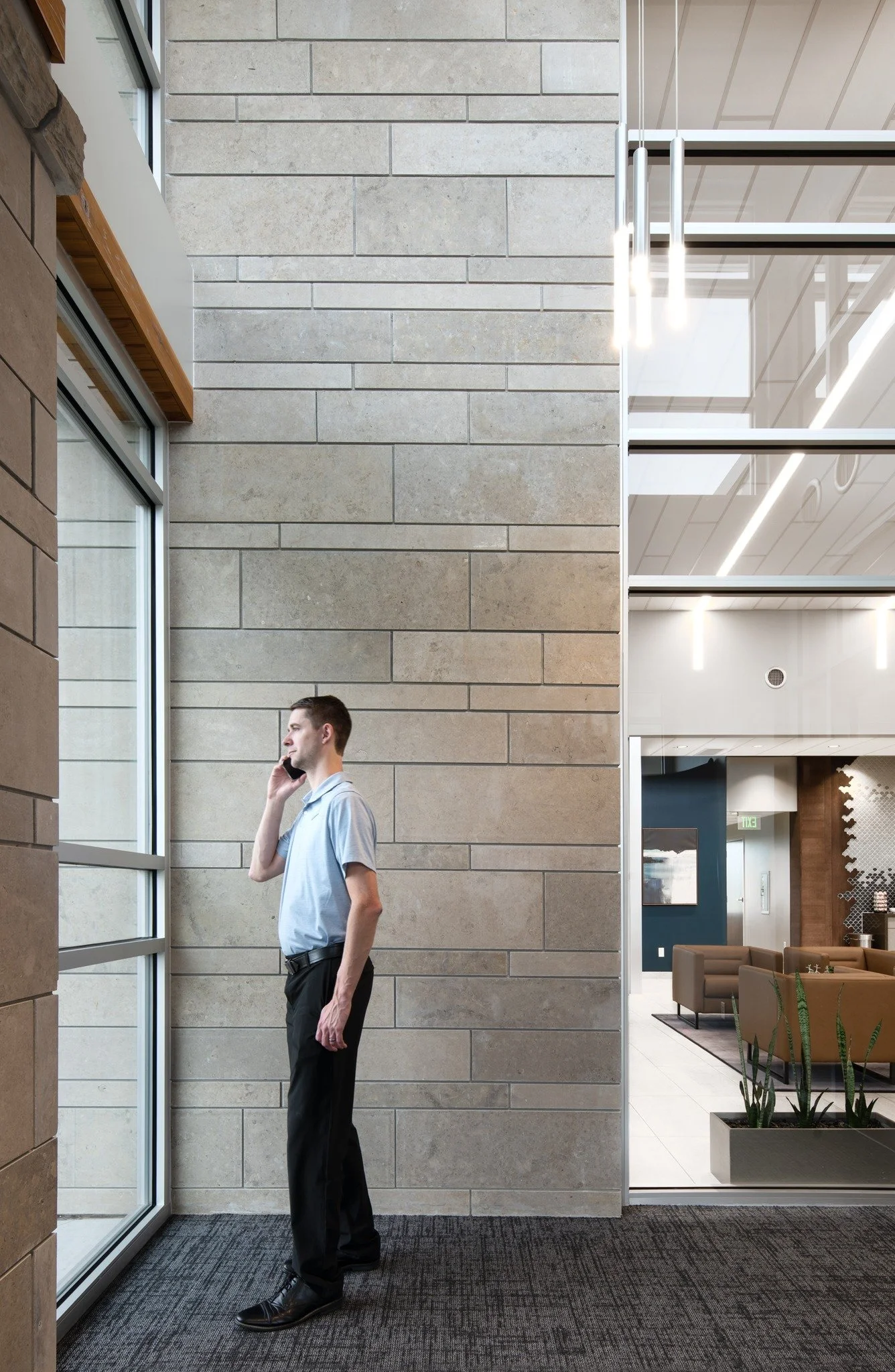 Flint Hills Gray clads a full height lobby pier in long thin courses beside the window wall.