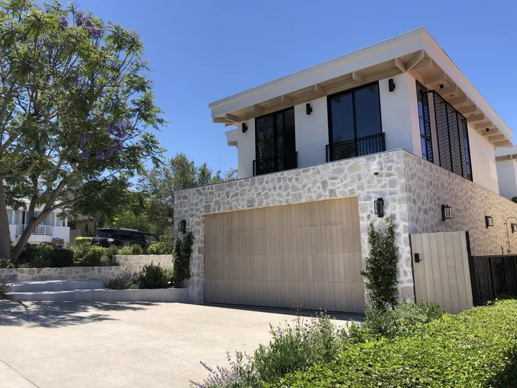 Tuscany Cream field veneer blended with 10% Charcoal framing a facade and entry, split and natural faces with overgrout joints.