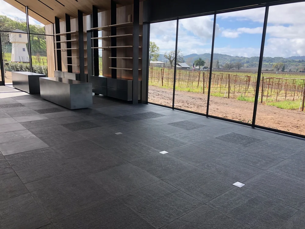 Flamed Black Mountain paving running across an interior room in square-edged units.