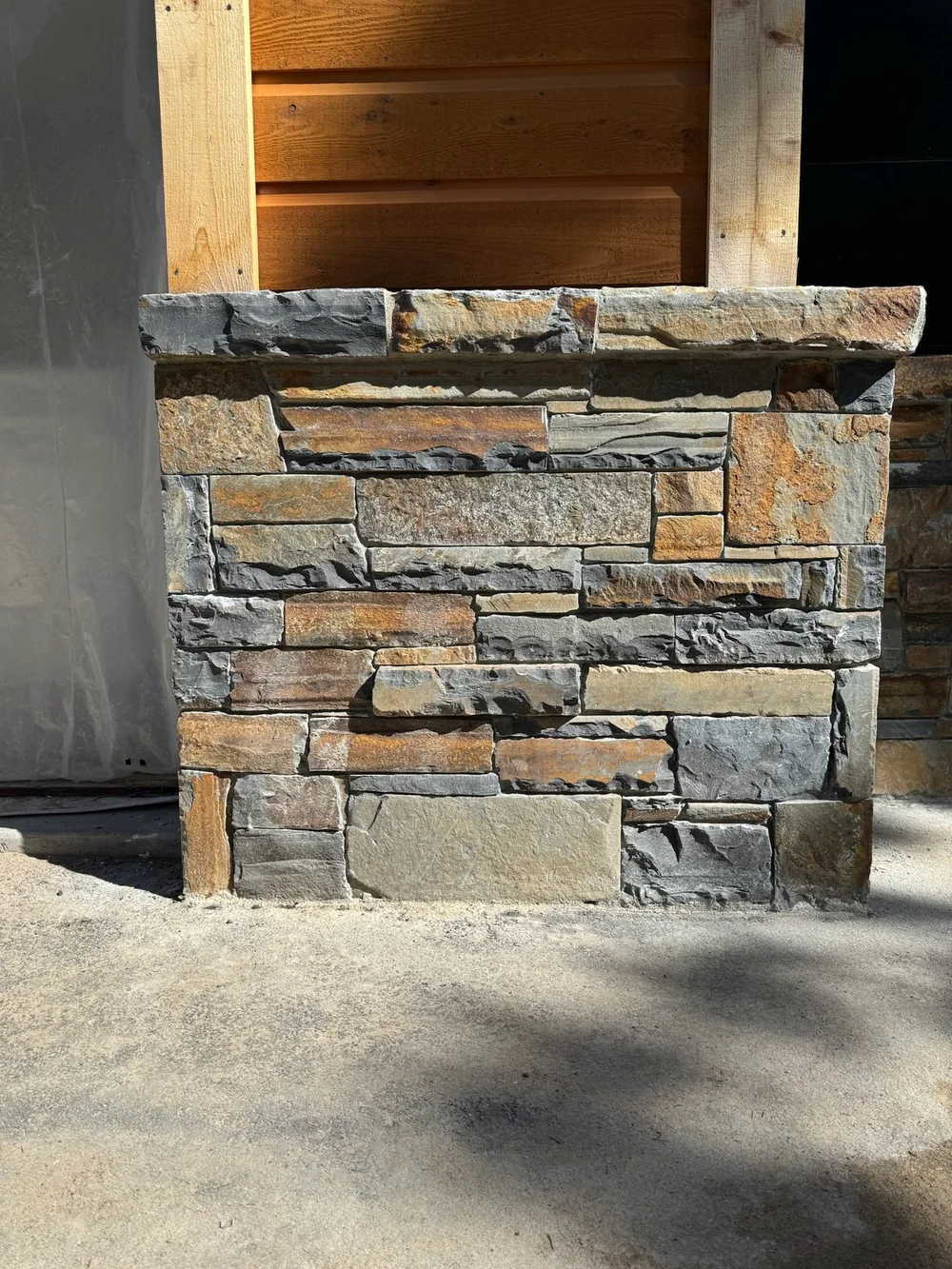Belt River ledgestone veneer in split and natural faces, finished with a natural-face wainscot cap on a facade.