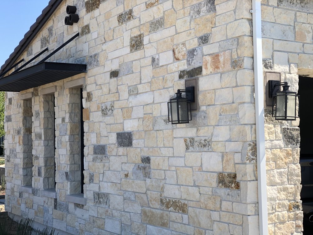 Split and natural Oceanside Estate ashlar veneer with honed Indiana Limestone sills and lintels on a home facade.