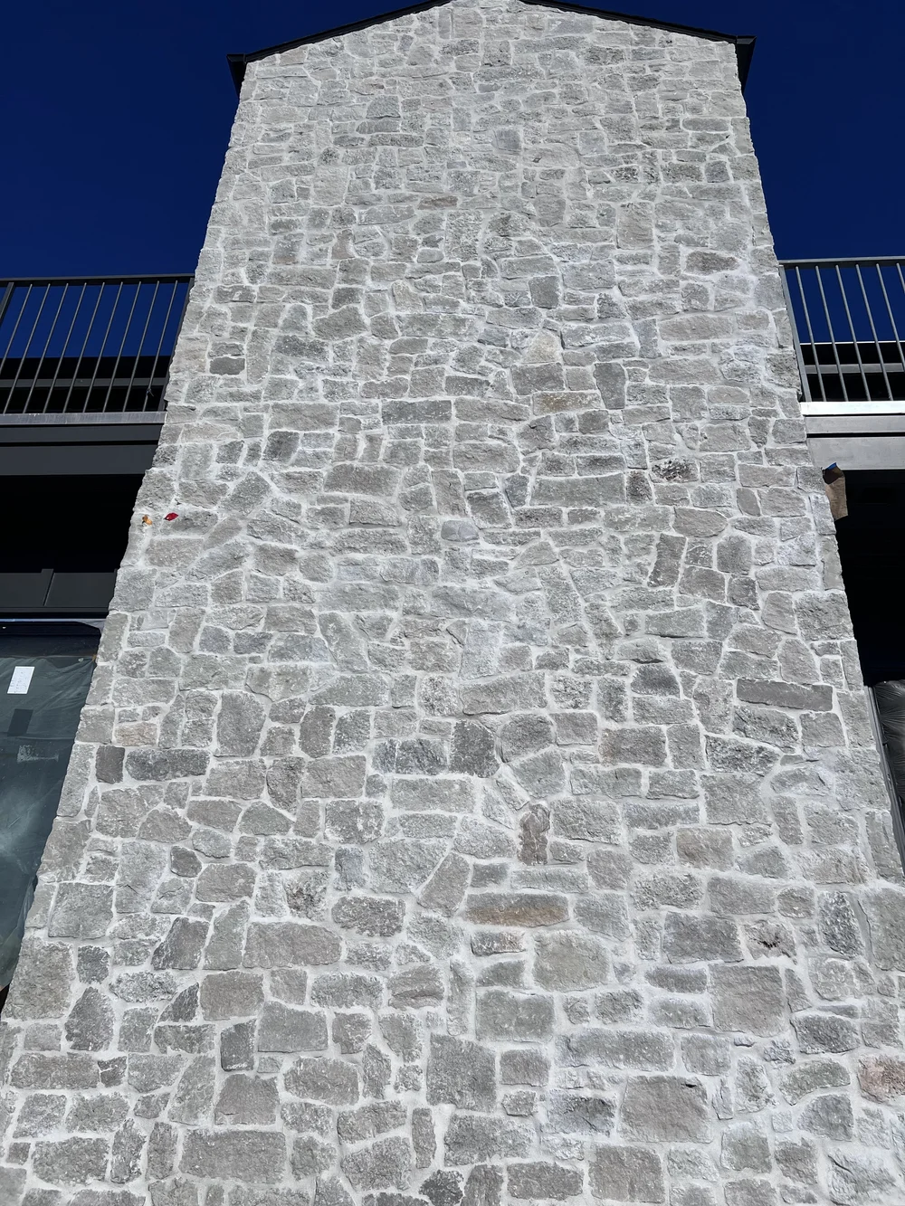 Tuscany Silver field veneer across a facade in split and natural faces with overgrout joints.