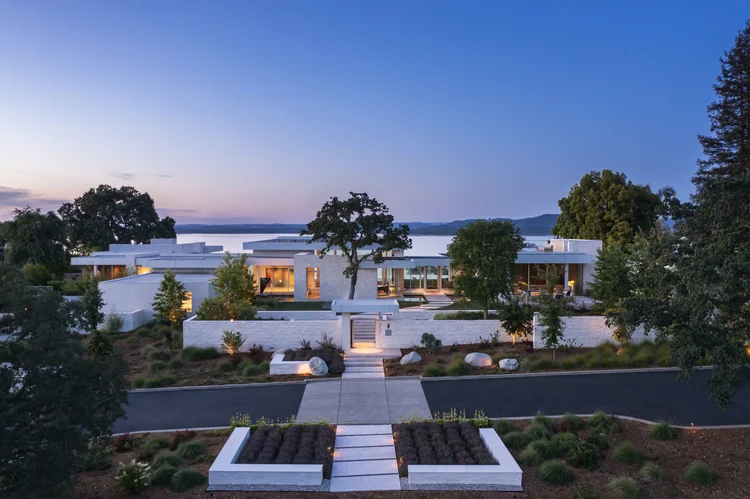 White coursed veneer with dry-stack joints and white honed wall caps at the entry, facade, and water feature of a Folsom home.