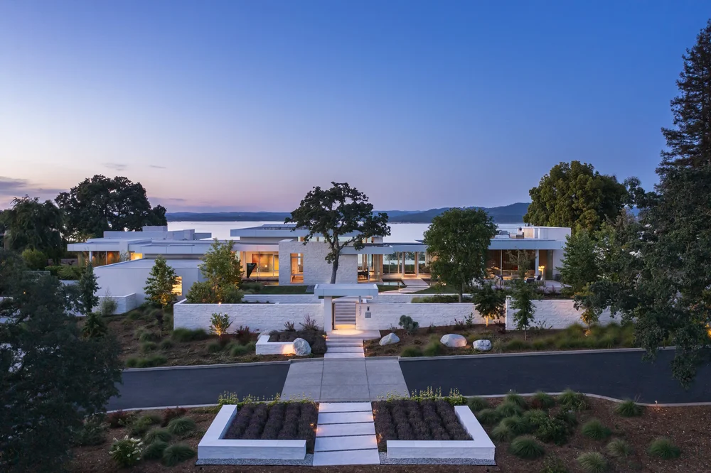 White coursed veneer with dry-stack joints and white honed wall caps at the entry, facade, and water feature of a Folsom home.