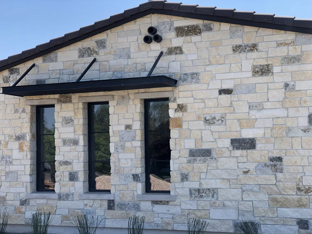 Oceanside Estate ashlar veneer with honed Indiana Limestone sills and lintels and raked joints across a home facade.