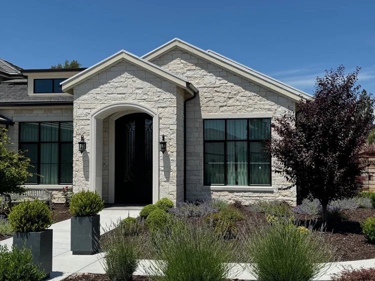 White coursed veneer with white sills, lintels, and jambs framing the entry of a Granite Bay home.