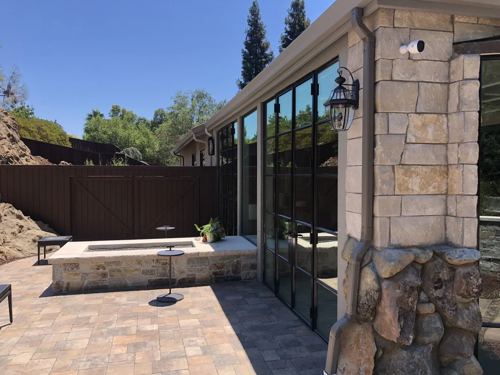 Buff ashlar veneer in split and natural faces with dry-stack joints and Indiana Limestone wall caps on a garden wall.