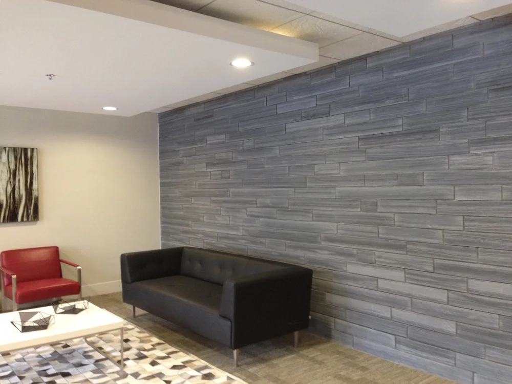Black Rundle Stone runs a sawn face feature wall in long thin courses behind a lounge seating group.