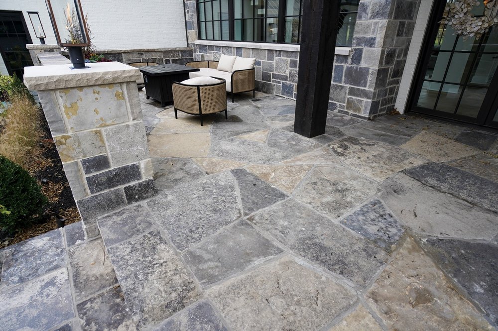 Graphite paves a courtyard terrace and carries up the pier and capped seat wall enclosing it.