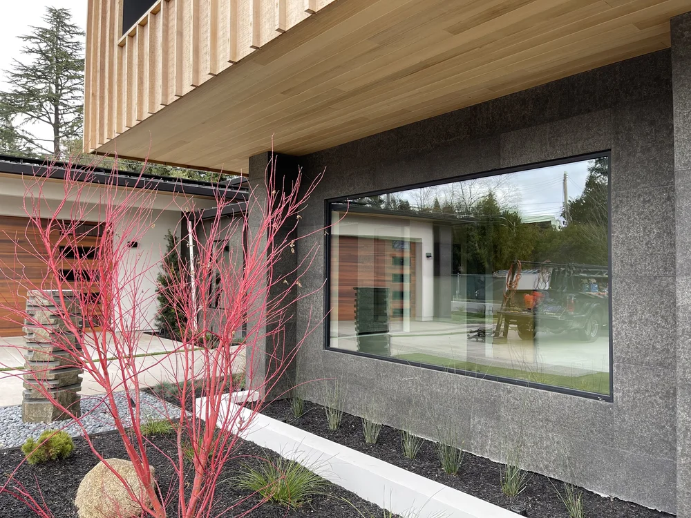 A Black Basalt base carries a long picture window beneath cedar soffit and siding.
