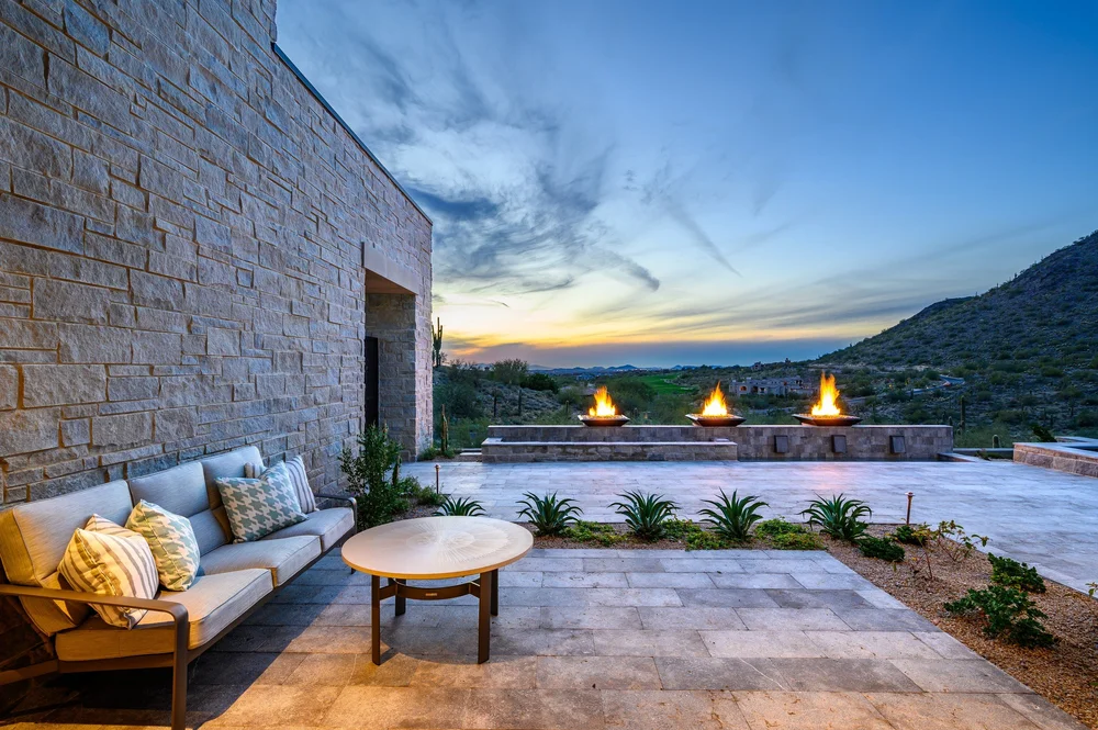 Gray Variegated runs the terrace wall past three fire bowls, the desert falling away at sunset.